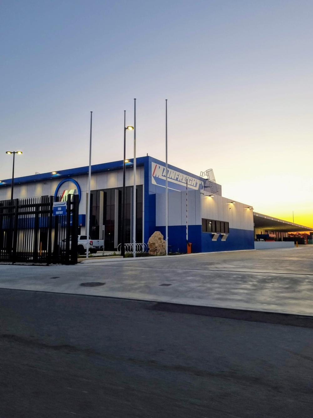Mainfreight building at dusk behind black security fencing
