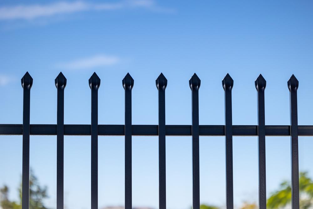 Close-up of black Garrison fence spear tops against the sky