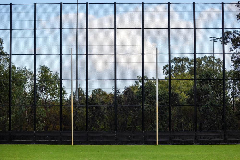 Tall black AFL back net behind goal posts